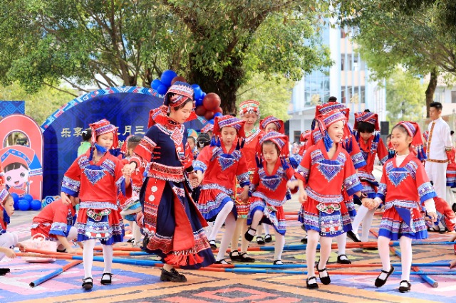 圖4：4月9日，在廣西柳州市融安縣實(shí)驗(yàn)小學(xué)校園，一名老師帶著學(xué)生跳竹竿舞。（譚凱興 攝）.JPG